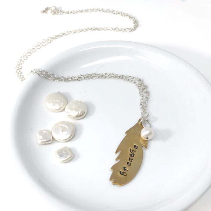 Handstamped feather in brass with pearl charm