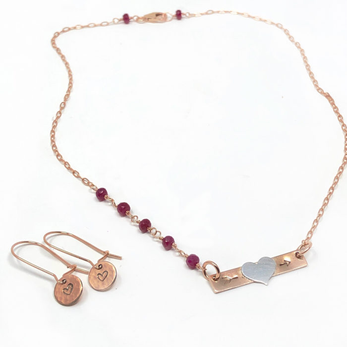 Rose gold bar necklace with heart initial and gemstones.
