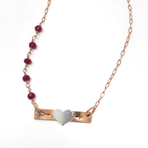 Rose gold bar necklace with heart initial and gemstones.