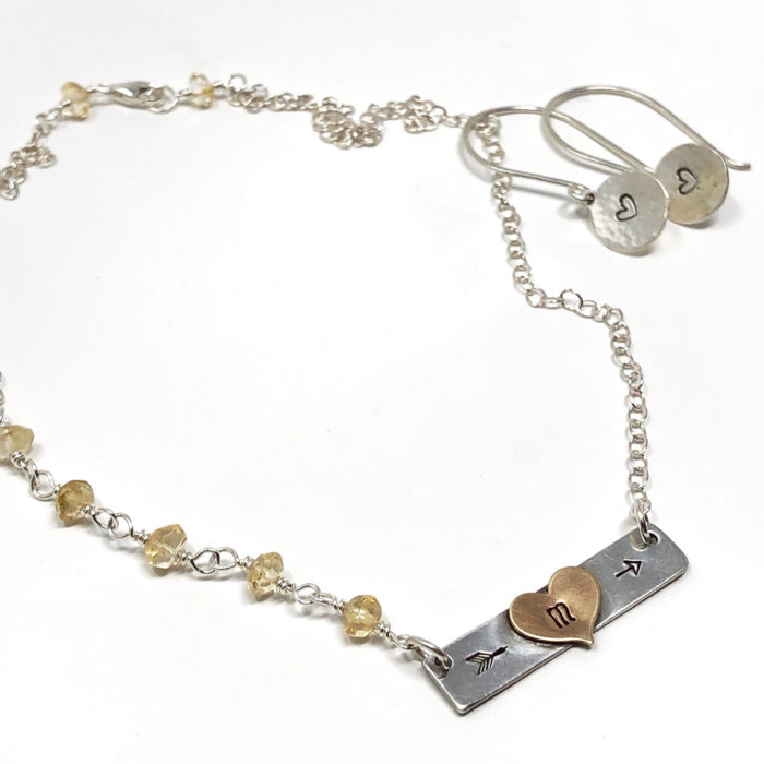 Silver bar necklace with heart initial and gemstones.
