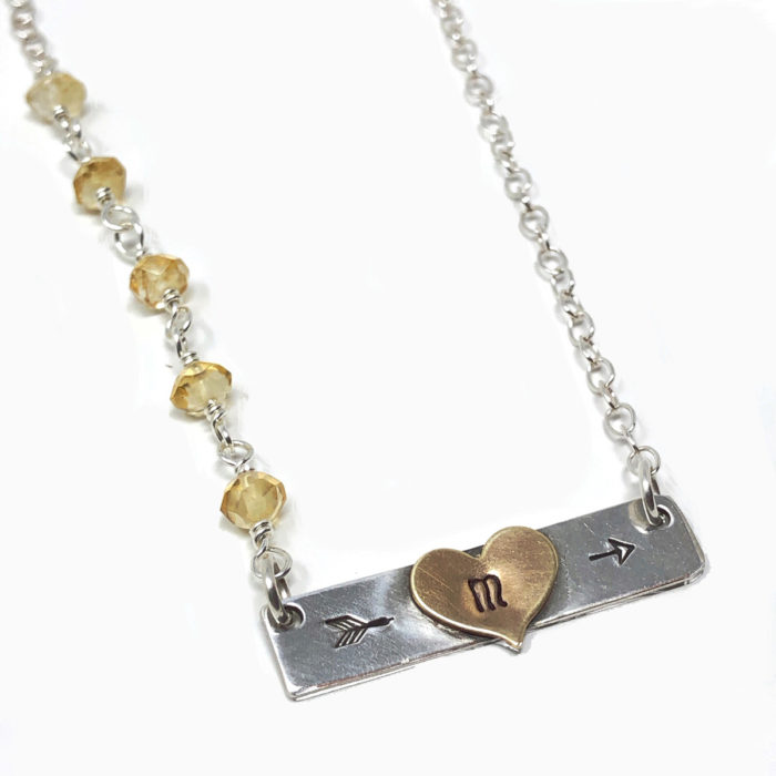 Silver bar necklace with heart initial and gemstones.